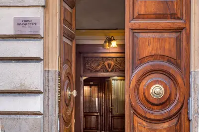 a wooden door of a building with a sign on it at Corso Grand Suite in Rome