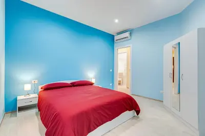 a blue bedroom with a bed with a red blanket at Monteverde Cozy Apartment in Rome