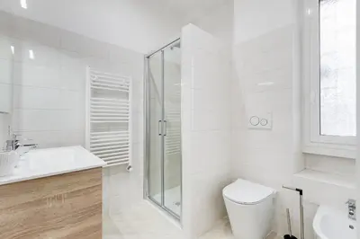 a white bathroom with a toilet and a shower at Monteverde Cozy Apartment in Rome