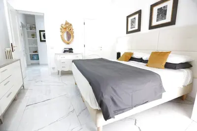 a white bedroom with a bed and a white tiled floor at DOLCE VITA VIMINALE ROOM in Rome