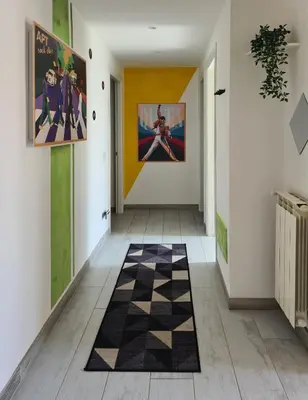 a hallway with a checkered floor and paintings at APT Re di Roma in Rome