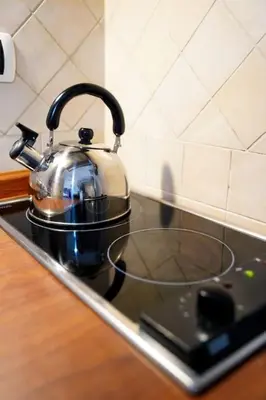 a kitchen with a blue table and a small kitchen at Villa Bonelli Loft in Rome