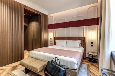 a hotel room with a large bed and a chair at THE STEPS Hotel - by Eitch Collection in Rome