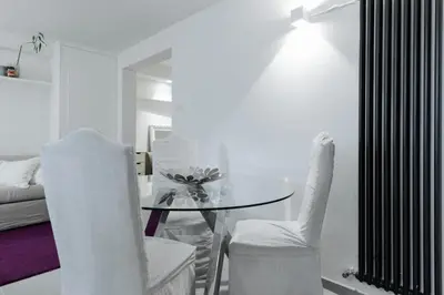 a dining room with a table and two white chairs at Pantheon Experience Suite in Rome