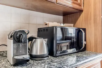a microwave sitting on a counter next to a coffee maker at Garbatella Elegant Apartment in Rome