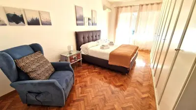 a bedroom with a bed and a couch and a chair at Garbatella Elegant Apartment in Rome