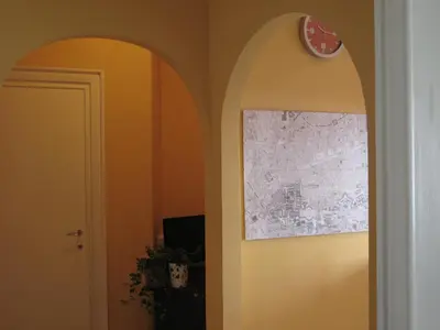 a hallway with an archway and a clock on the wall at Arches Inn in Rome