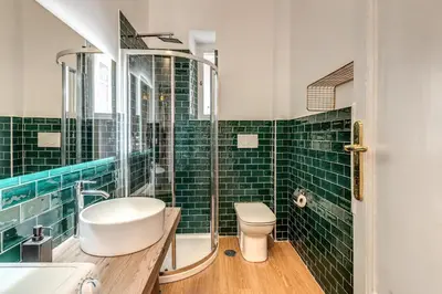 a green tiled bathroom with a toilet and a sink at The Great Green in Rome