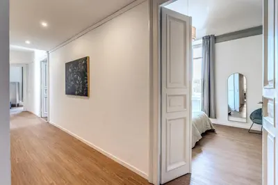 a bedroom with white walls and a bed and a mirror at The Great Green in Rome