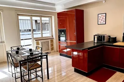 a kitchen with a counter and a table with chairs at Luxurious flat close to the Vatican/metro in Rome