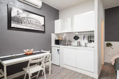 a kitchen with white cabinets and a table in a room at Magenta Collection Terrione 25 in Rome
