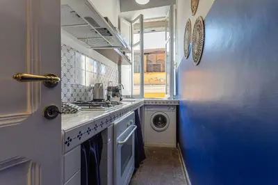 a kitchen with a washing machine and a blue wall at Demetra - Little Loft a Trastevere in Rome