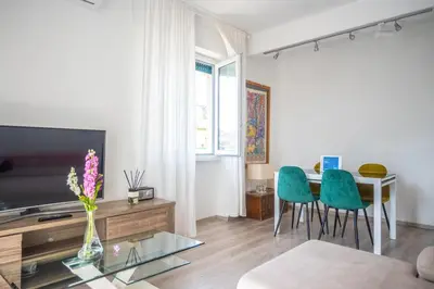 a living room with a tv and a table and chairs at Families apartment in Rome