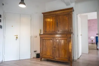 a large wooden cabinet in a room with a door at Families apartment in Rome