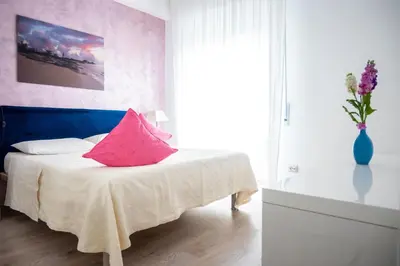 a bedroom with a bed with a pink pillow on it at Families apartment in Rome