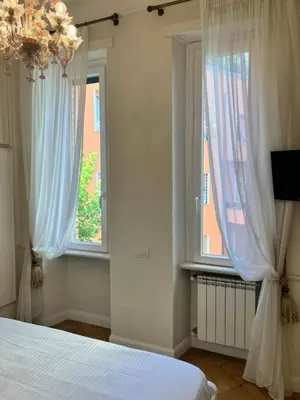 a bedroom with a bed and two windows at Circo Massimo Sweet Home - next to FAO in Rome