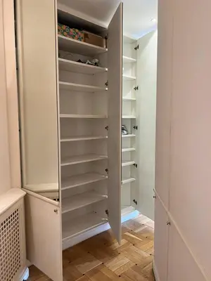 a walk in closet with white cabinets and wood floors at Circo Massimo Sweet Home - next to FAO in Rome