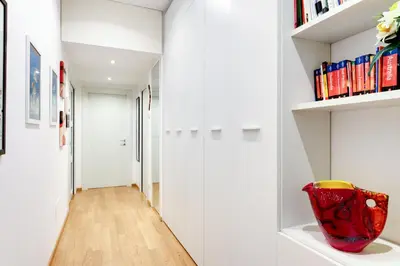a hallway with white walls and a red vase on a shelf at Lovely apartment in Rome - Casetta Mattei in Rome