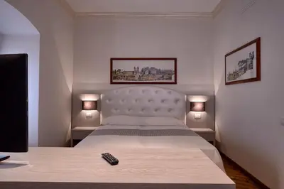 a bedroom with a large bed with a remote control on it at Polinari Rooms San Pietro Roma in Rome