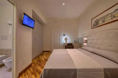 a bedroom with a bed and a tv on the wall at Polinari Rooms San Pietro Roma in Rome