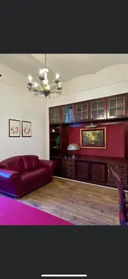 a living room with a red couch and a chandelier at La casetta a monti in Rome