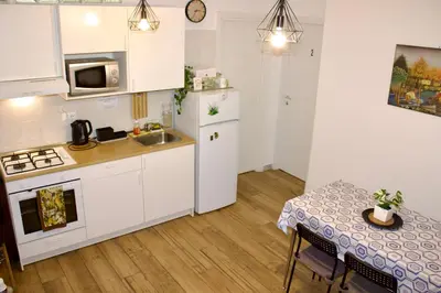 a kitchen with white cabinets and a table and a table and a table at GOLDEN ROOMS Cipro in Rome