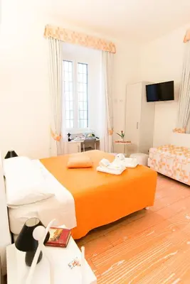 a hotel room with a large bed and a television at Divine Bed & Breakfast in Rome