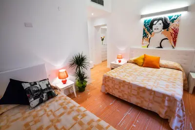 a bedroom with two beds and a painting on the wall at Divine Bed & Breakfast in Rome