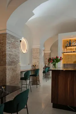 a dining room with a bar with green chairs at Argentina Residenza Style Hotel in Rome