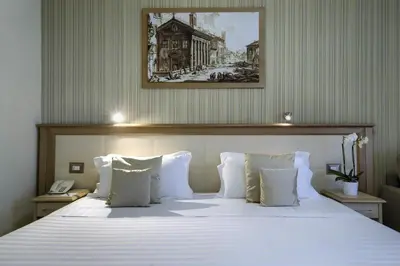 a bedroom with a large bed with white pillows at Domus Australia in Rome