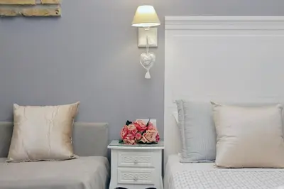 a bedroom with two beds and a table with flowers on it at Roman Holiday Suites in Rome