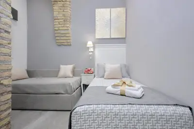 a bedroom with a bed and a couch at Roman Holiday Suites in Rome