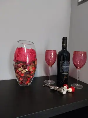 a bottle of wine and two glasses and a candle at j u b i l e h o u s e R o m e in Rome