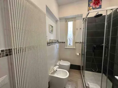 a bathroom with a shower and a toilet and a sink at Family Flat near Metro A in Rome