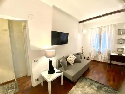 a living room with a couch and a tv on a wall at NAVONA SUITE VIOLA in Rome
