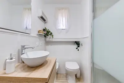 a white bathroom with a sink and a toilet at Pigna suite in Rome