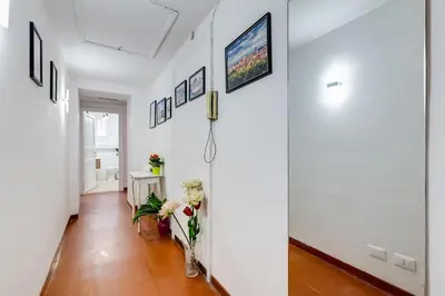 a hallway with a white wall with pictures at Pigna suite in Rome