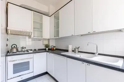 a white kitchen with white cabinets and a sink at 2 Vatican St Peter's Daniele apartment Barone in Rome