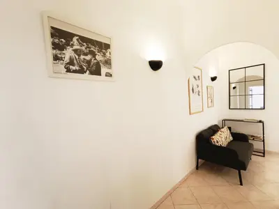 a living room with a chair and a picture on the wall at LAVINIA VATICAN HOME in Rome