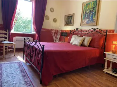 a bedroom with a bed with a red bedspread at DOMUS ANNIA Guest House, The Amazing Colosseum in Rome