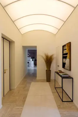 a hallway with a white ceiling and a table at Le Case di Andrea - Luxe Rome apartment in Rome