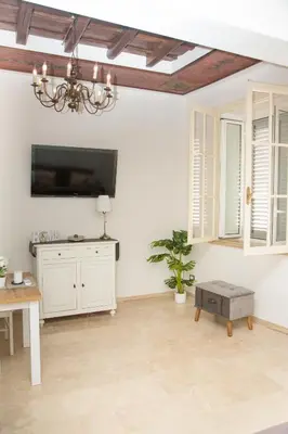 a living room with white walls and a ceiling with a chandelier at Casa vacanza Colosseo 2 in Rome