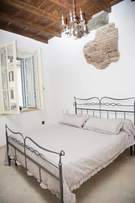 a bed in a white room with a chandelier at Casa vacanza Colosseo 2 in Rome