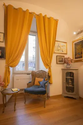 a living room with a chair and a window at La Casa di Vittorio boutique Ottaviano San Pietro in Rome