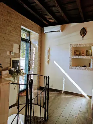 a living room with a staircase in a house at Trastevere's Nest in Rome