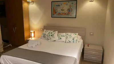 a bedroom with a bed with white sheets and pillows at Frank Host Roma Lux , Metro A a 50 m, simple check-in con codice a qualsiasi orario in Rome