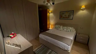 a bedroom with a bed and a table with flowers on it at Frank Host Roma Lux , Metro A a 50 m, simple check-in con codice a qualsiasi orario in Rome