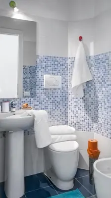 a blue and white bathroom with a toilet and a sink at Ulysses in Rome in Rome