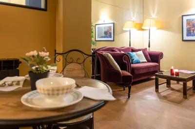 a living room with a couch and a table at Cloe Suite - A due passi da Villa Borghese in Rome