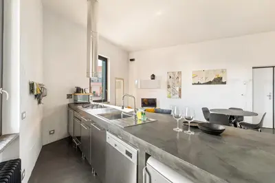 a kitchen with a sink and a counter with wine glasses at Fantastic Penthouse over the Roman Sky in Rome